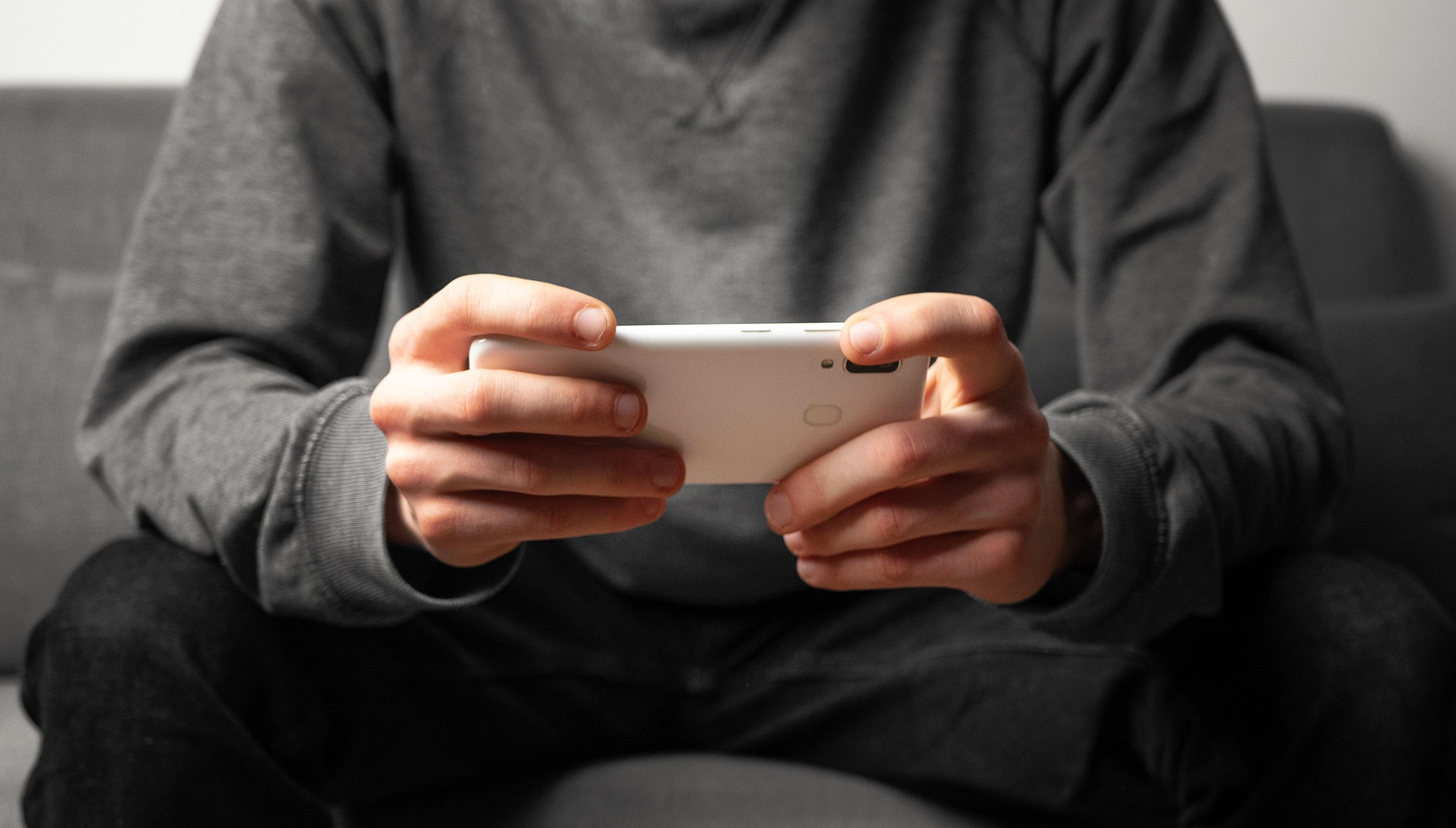 A man looking at his phone in landscape mode